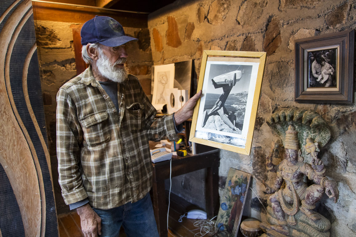 Hal Newell in his Darwin home showing a photo of one of his father's sculptures at Big Sur. Photo: Kim Stringfellow.