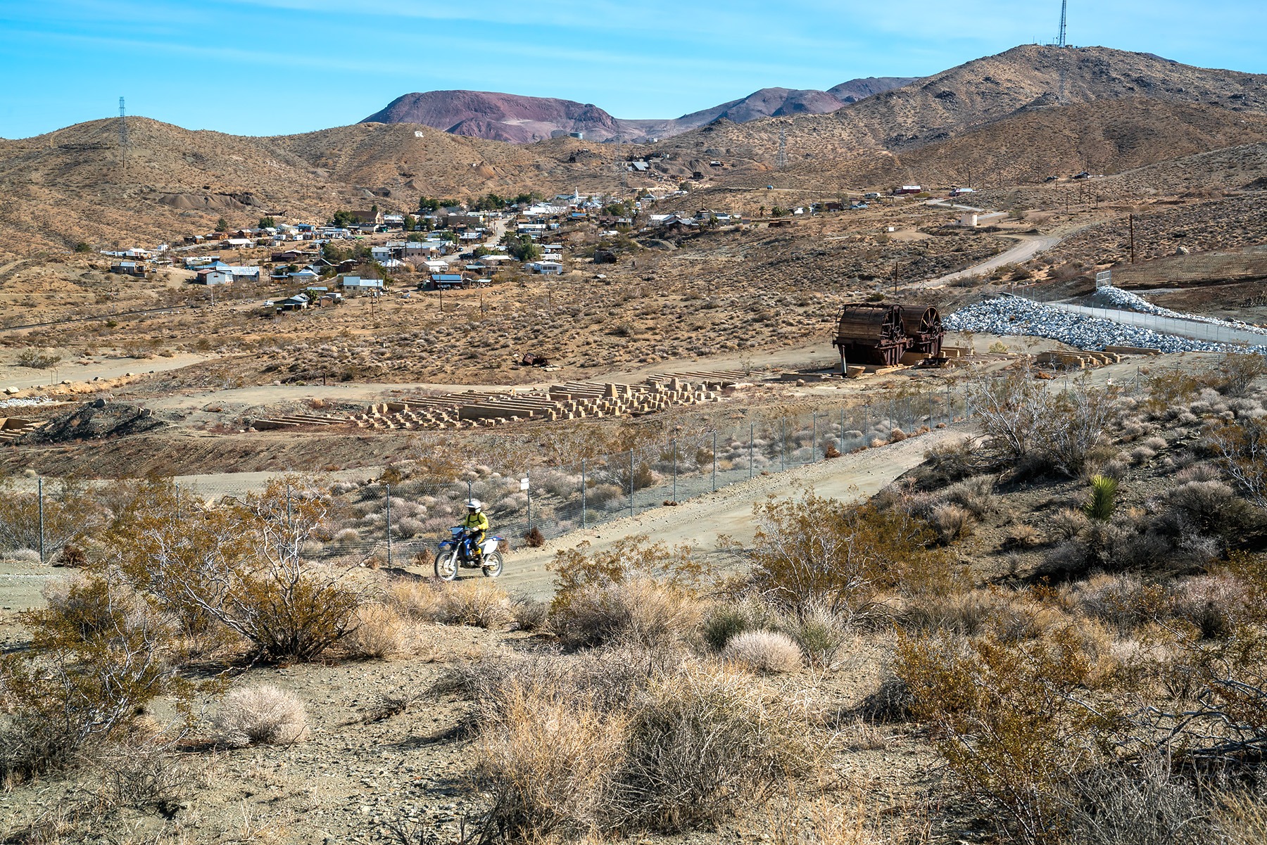 A solo dirt bike rider motors by Randsburg’s defunct mill site that is considered by federal authorities to be highly contaminated with arsenic from historic mining activity in the area. Photo: Kim Stringfellow.
